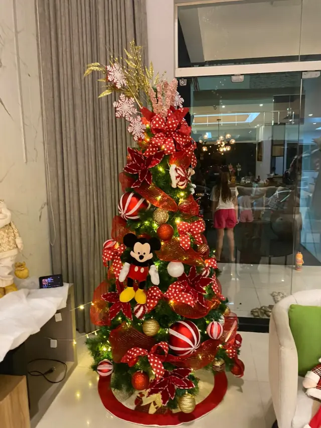 Árvore decorada com laços de poá, ornamentos coloridos e personagem Mickey.