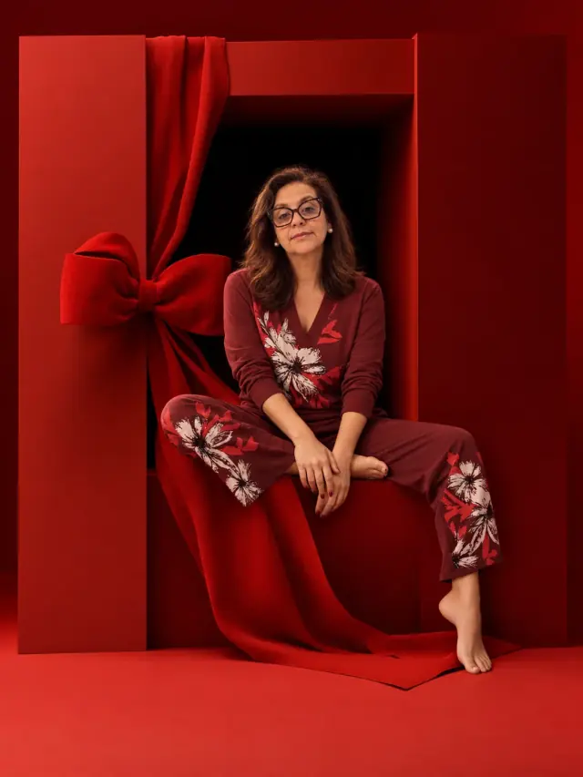 Angela Muniz em um cenário de Natal em tons de vermelho.